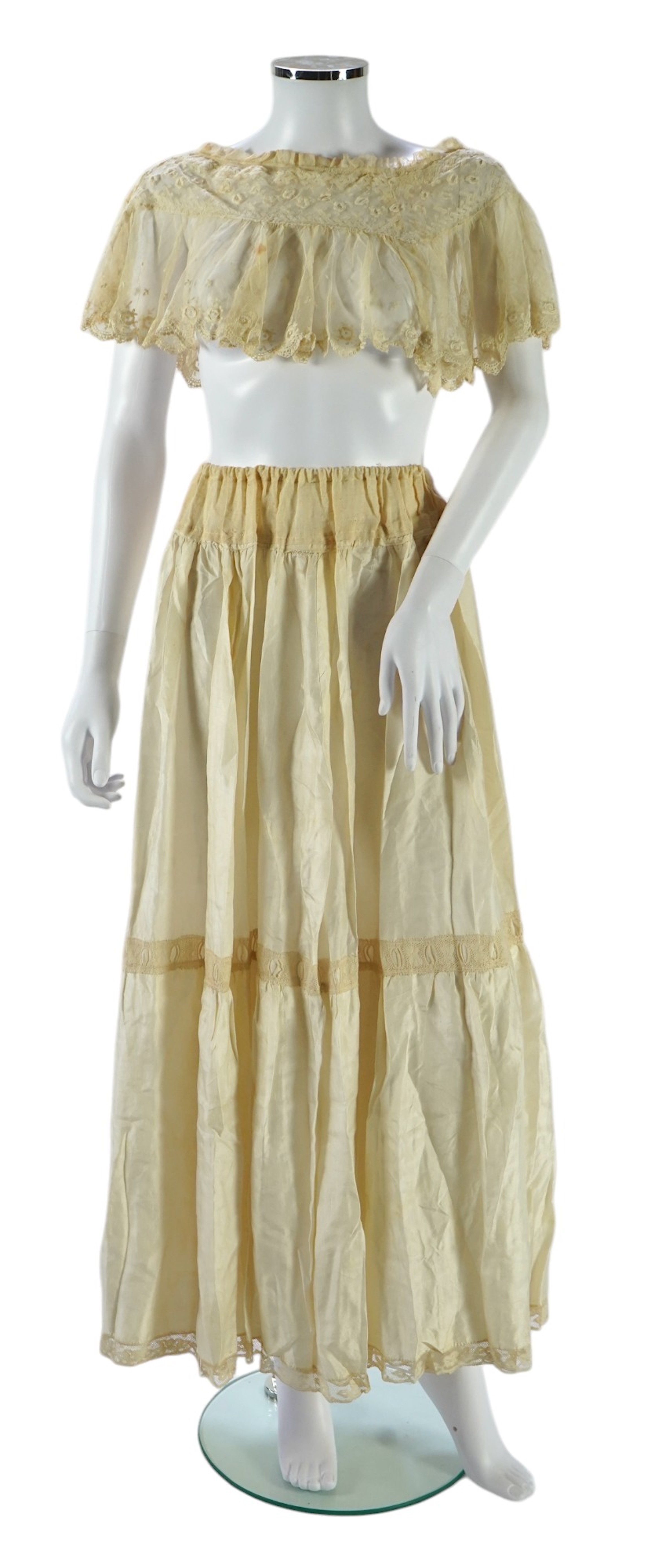 A suitcase containing a cream silk lace skirt to a dress, an Edwardian silk petticoat and various collars, possibly for theatrical use, silk petticoat 96 cm long. Condition - fair